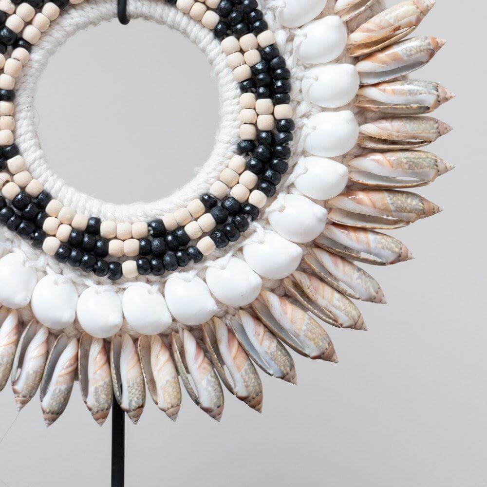 Detail van moderne grijze schelpenketting op standaard, met exotische uitstraling van Earthware.