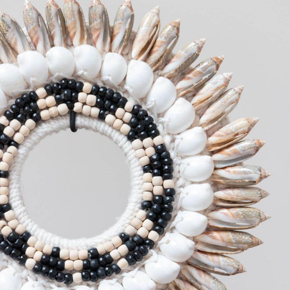 Decoratieve grijze schelpenketting met kralen op standaard, voor een exotische sfeer in huis. Perfect als stijlvolle woonaccessoire.