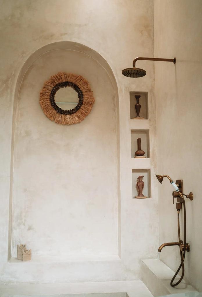 Boho spiegel Mowgli in witte badkamer, voegt licht en stijl toe.