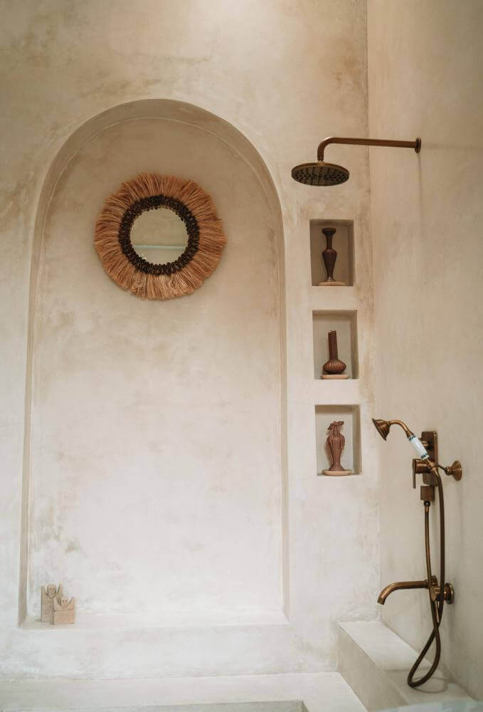 Handgemaakte Boho spiegel Mowgli in een sfeervolle badkamer met boho elementen en warme tinten.