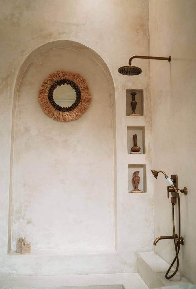 Handgemaakte Boho spiegel Mowgli in een sfeervolle badkamer met boho elementen en warme tinten.