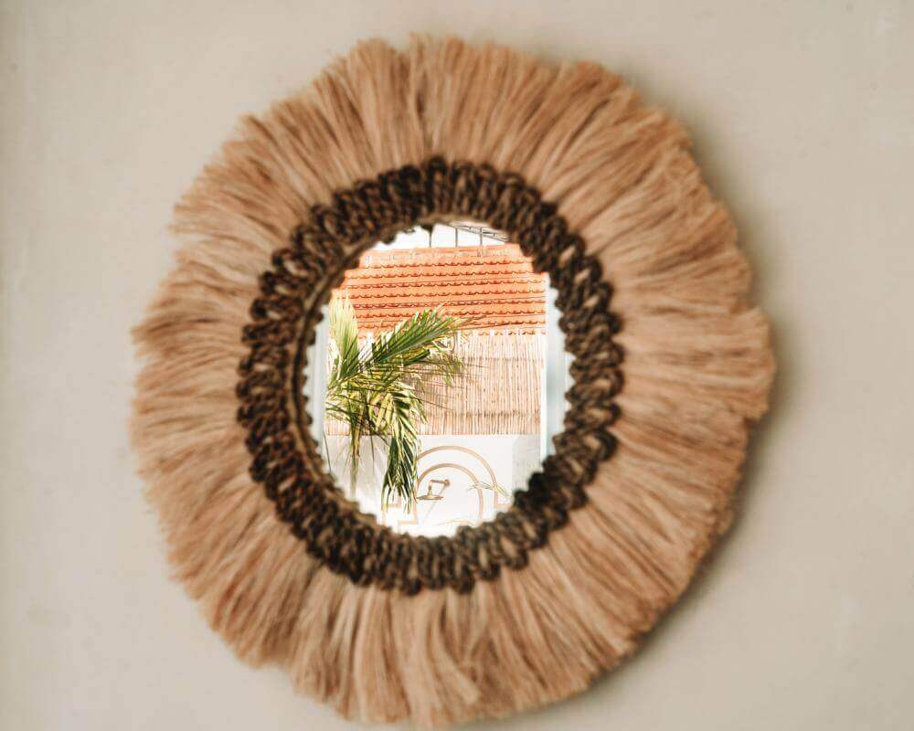 Boho spiegel Mowgli met handgemaakte rand, ideaal voor extra sfeer en diepte in je interieur. Decoratieve ronde spiegel aan wand.