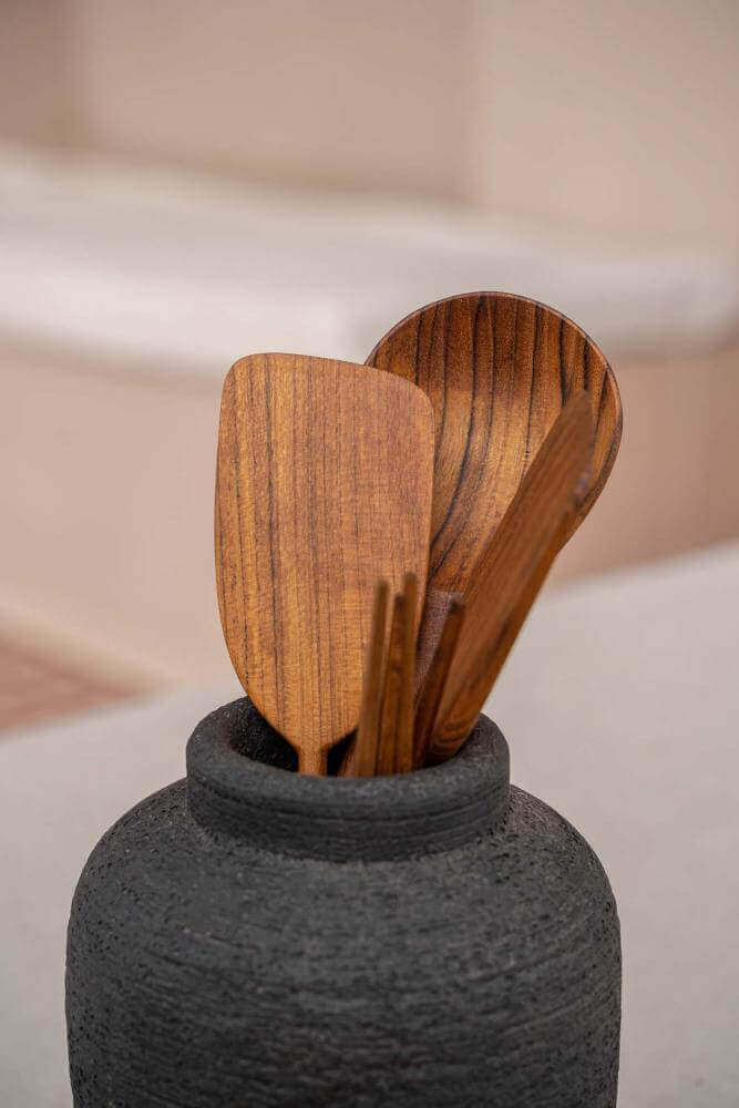 Houten lepels in een boho terracotta vaas, perfect voor een rustieke en natuurlijke look in de keuken.