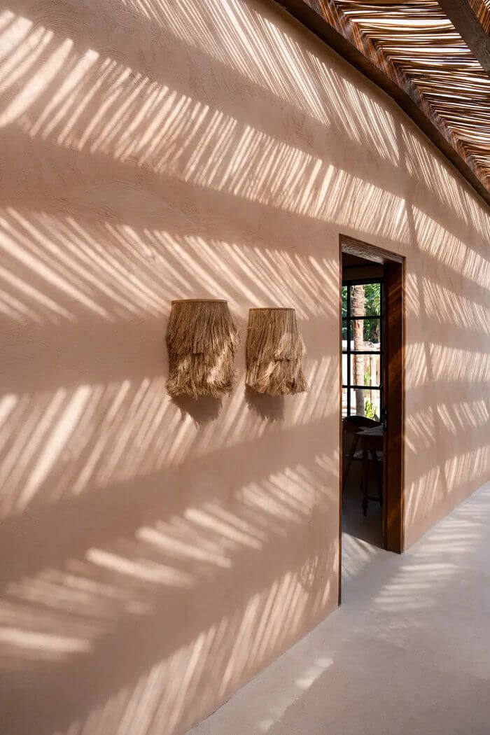 Alt Tag: Moderne muur met De Abaca Applique Muurlamp, natuurlijke uitstraling en schaduwpatronen, handgemaakt en stijlvol ontwerp.