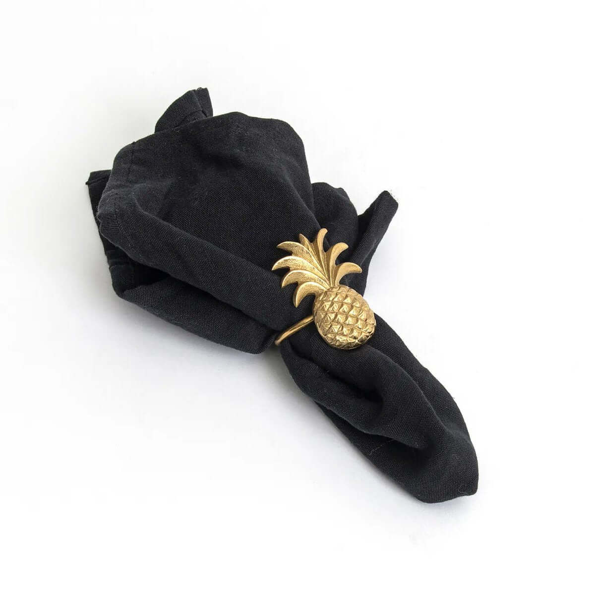 Bohemian gold pineapple napkin ring in solid brass on black fabric, adding luxury to table decor.