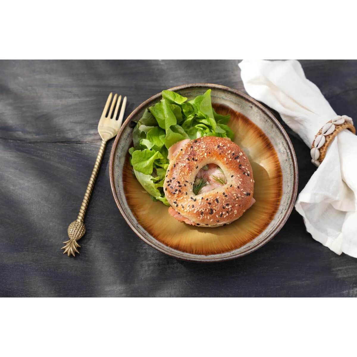 Bohemian gold pineapple fork beside a gourmet bagel salad, showcasing elegant dining with De Ananasvork - Goud.