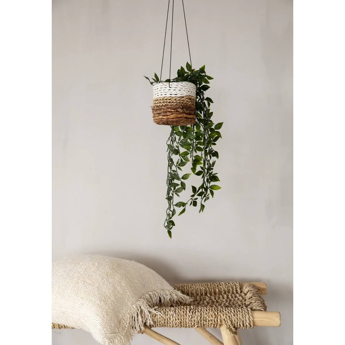 Bohemian style banana leaf and seagrass hanging planter in white and orange with greenery, perfect for indoor decor.