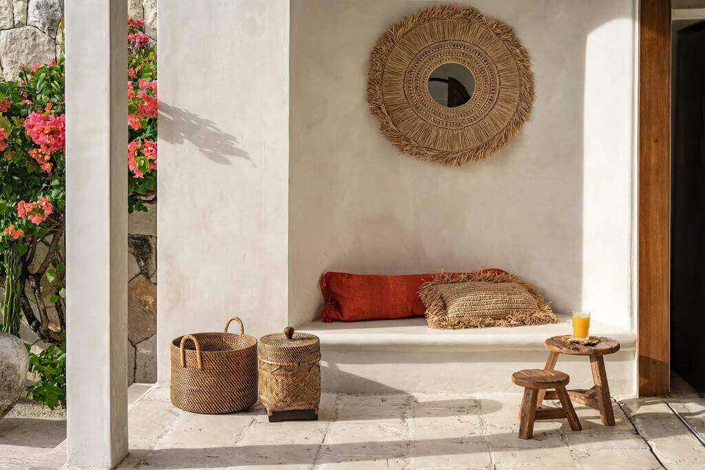 Alt Tag: Rustieke zithoek met handgevlochten rotan mand en decoraties in natuurlijke kleuren in een mediterrane setting.