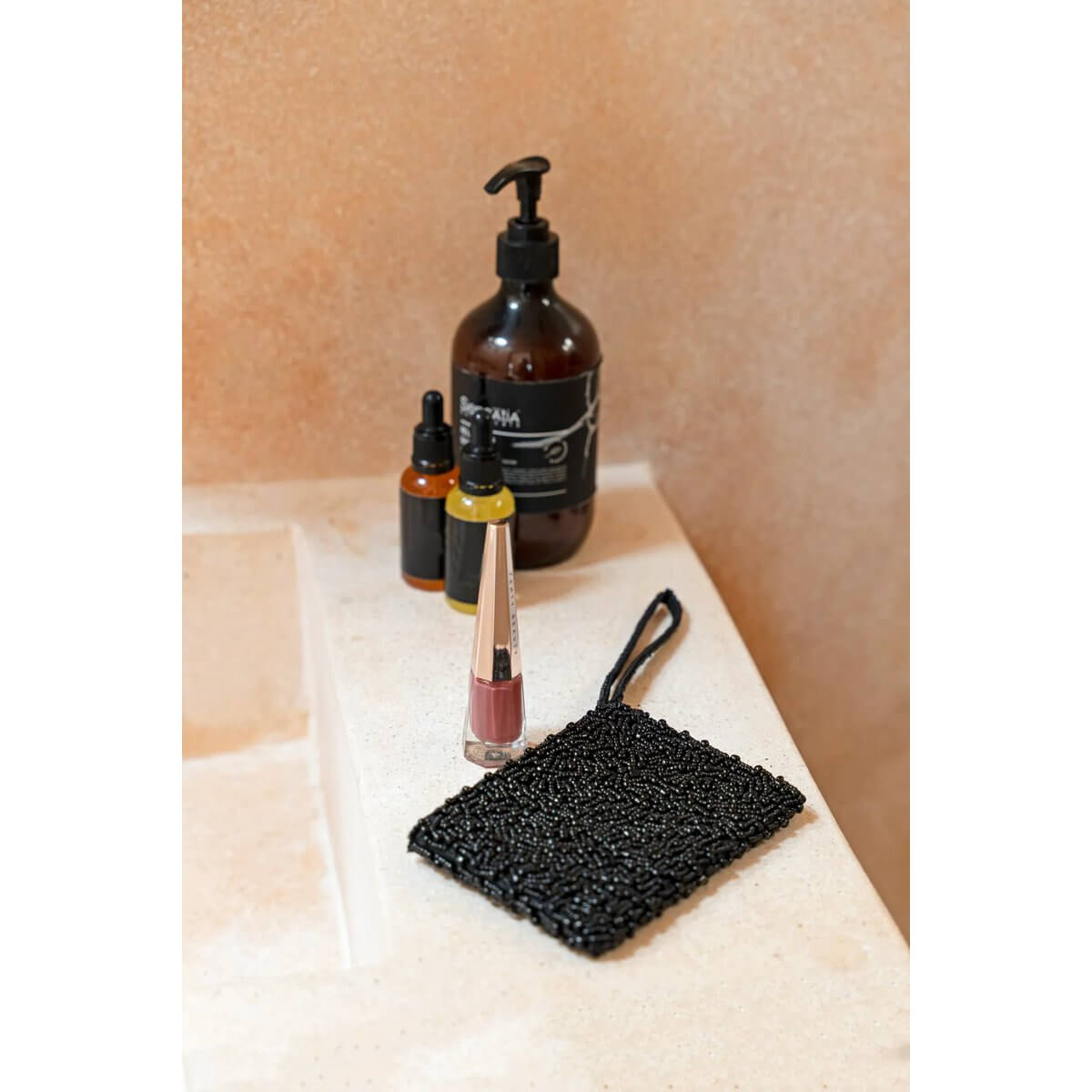 Bohemian Black Pearl Wallet on countertop beside stylish toiletries, exuding elegance and compact design for effortless sophistication.