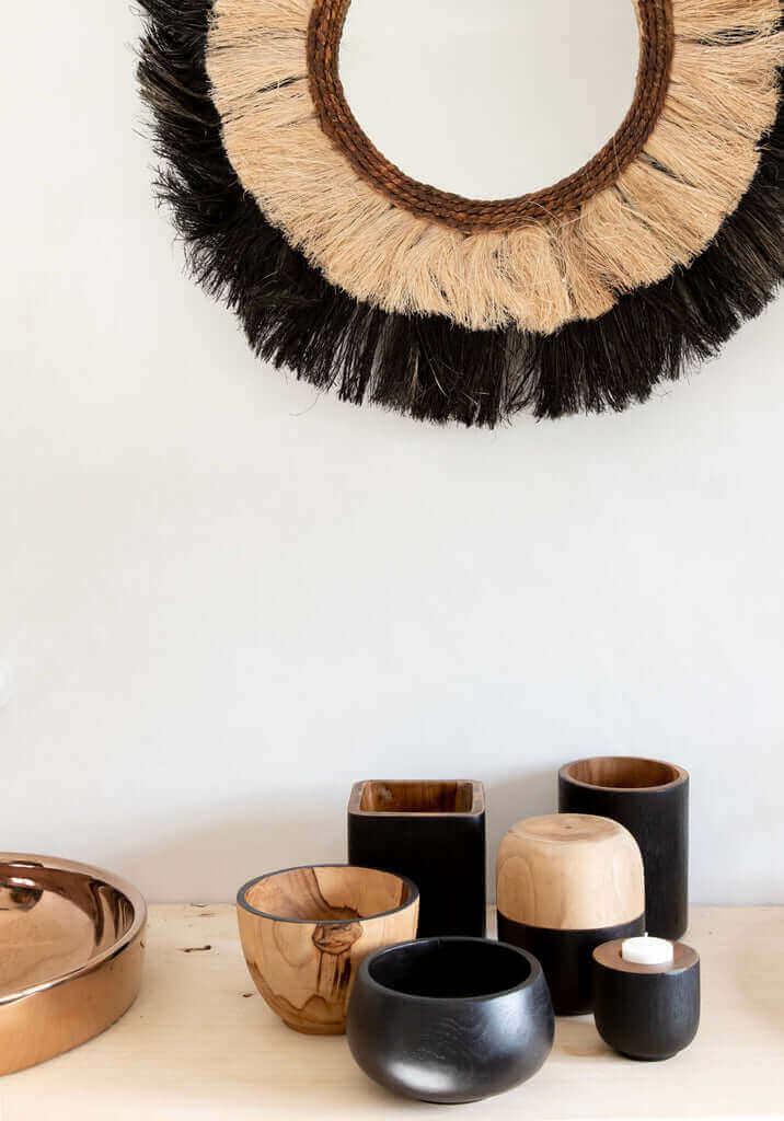 Teakhouten schalen en decoratieve accessoires in natuurlijke en zwarte tinten, perfect voor stijlvolle opbergruimte in huis.