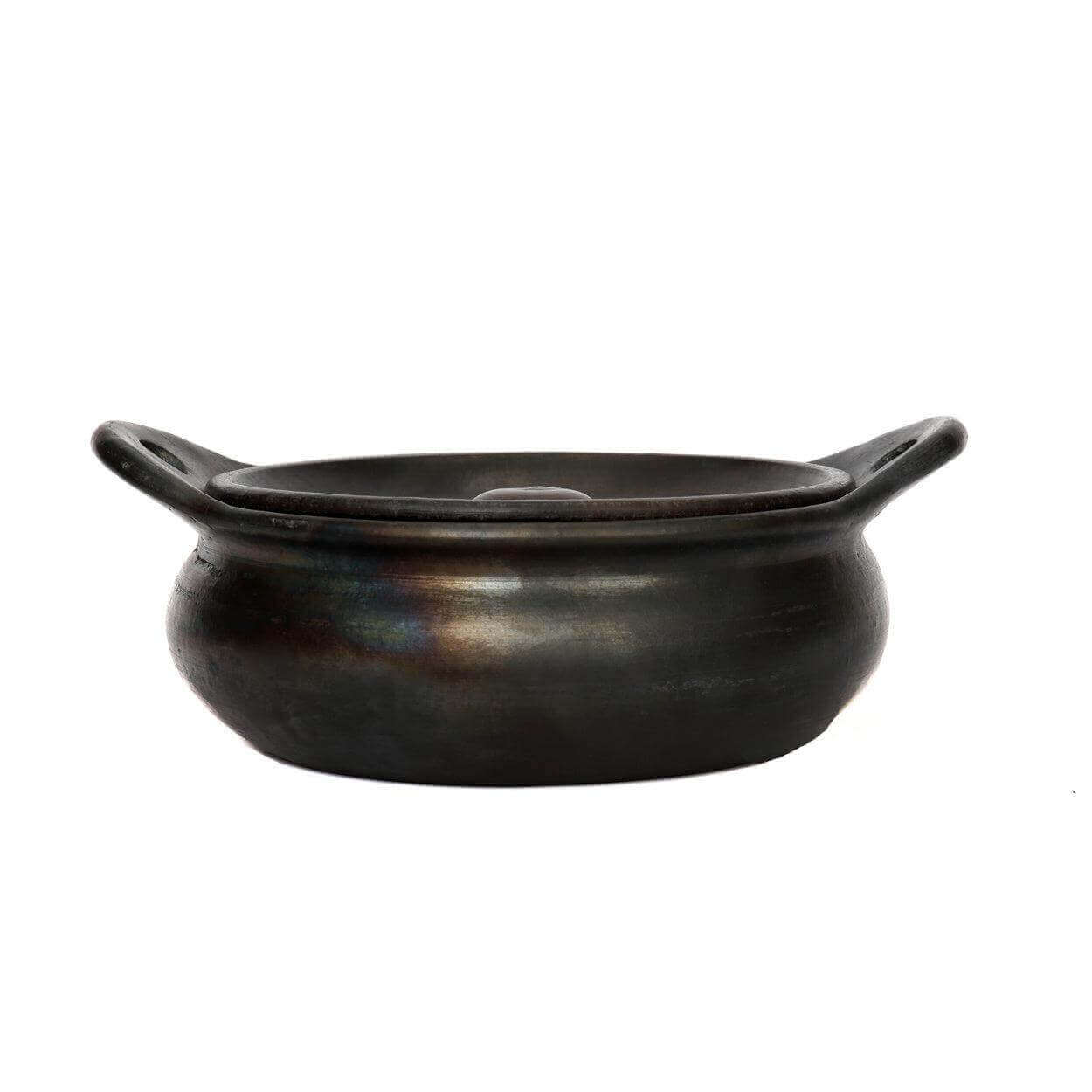 De Burned Casserole - Zwarte serveerpot van gebrande terracotta, vaatwasmachinebestendig met uniek ontwerp en deksel. Perfect voor de eettafel.