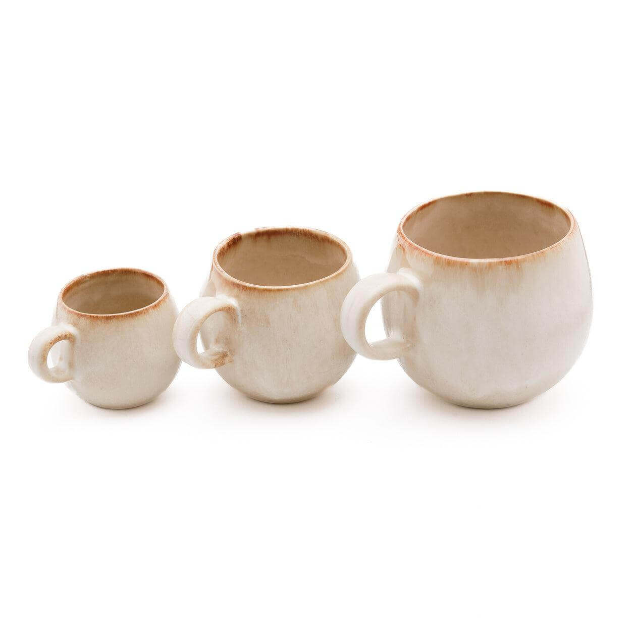 Drie witte koffiemokken met een vleugje geel, handgemaakt Portugese keramiek. Perfect voor elke tafelsetting of gelegenheid.