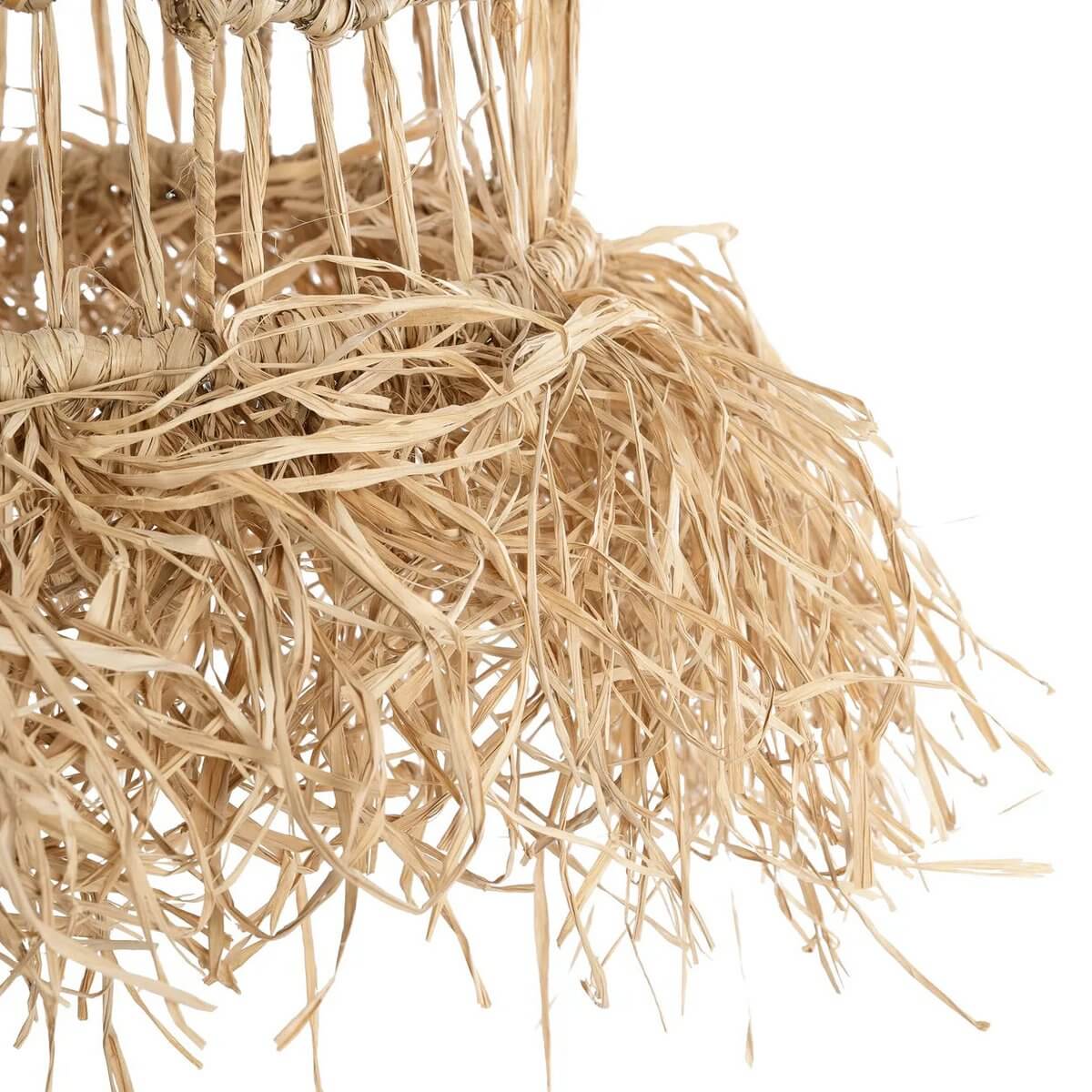 Close-up van natuurlijke Casita hanglamp met mendonggras en franjes voor tropische sfeer in huis.
