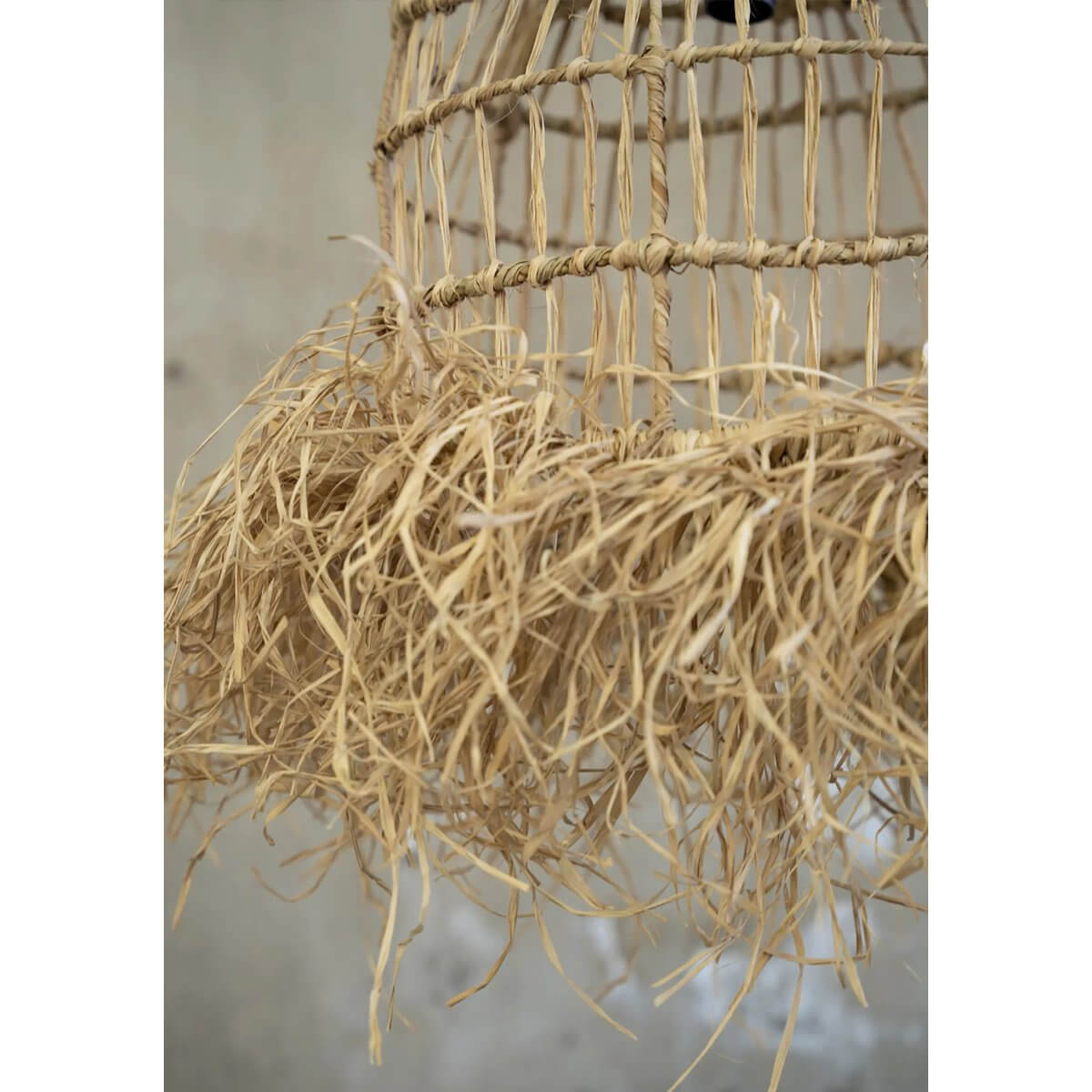 Bohemian-style Casita hanger lamp made from natural mendong grass, featuring intricate fringes for tropical light patterns.