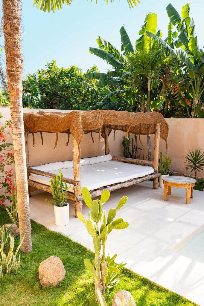 Alt Tag: Loungebed onder De Coco Shade Rechthoekig in een tropische tuin, gemaakt van duurzaam kokosvezel. Perfect voor relaxen en nature vibes.