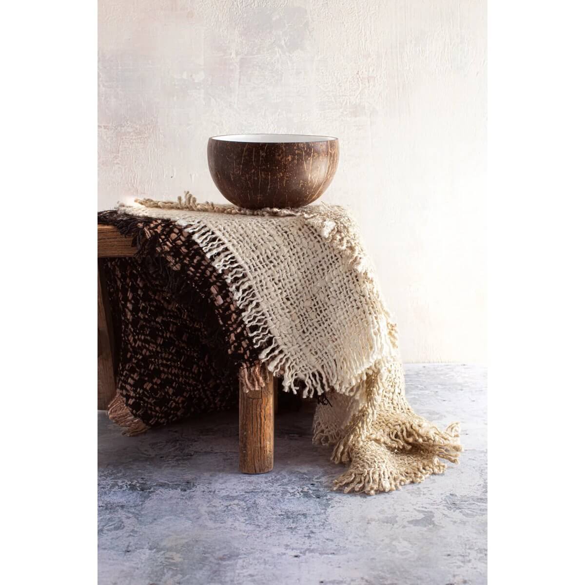 Bohemian-style coconut bowl on a textured cloth, perfect for smoothies or breakfast, adding a tropical touch to any space.
