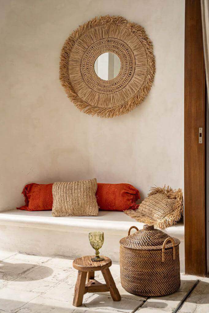 Koloniale stijl woonkamer met rotan mand, spiegel en kussens, creëert een rustieke en warme sfeer. Perfect voor sfeervol opbergen in naturel bruin.