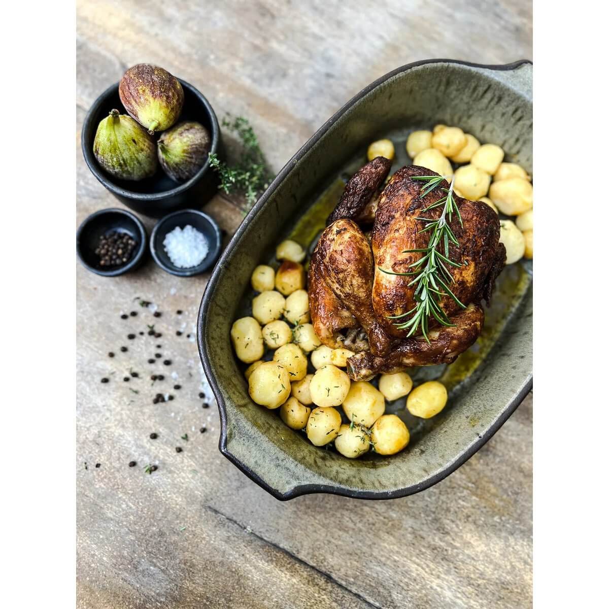 Heerlijke gebraden kip met aardappelen in stijlvolle grijsgroene De Comporta ovenschaal, perfect voor elegante diners.
