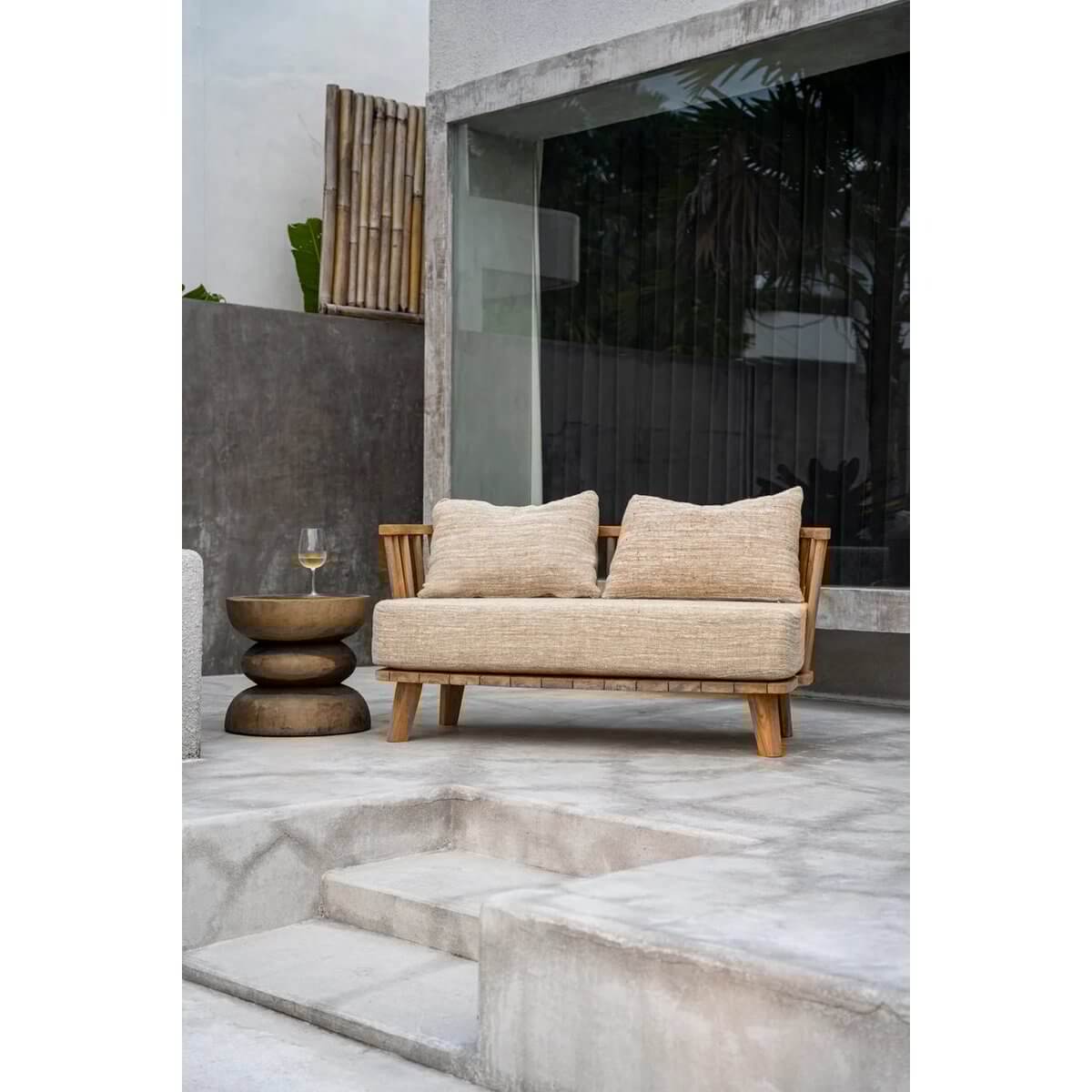 Bohemian outdoor setup with a woven sofa and spiral stool made from natural materials on a modern patio.