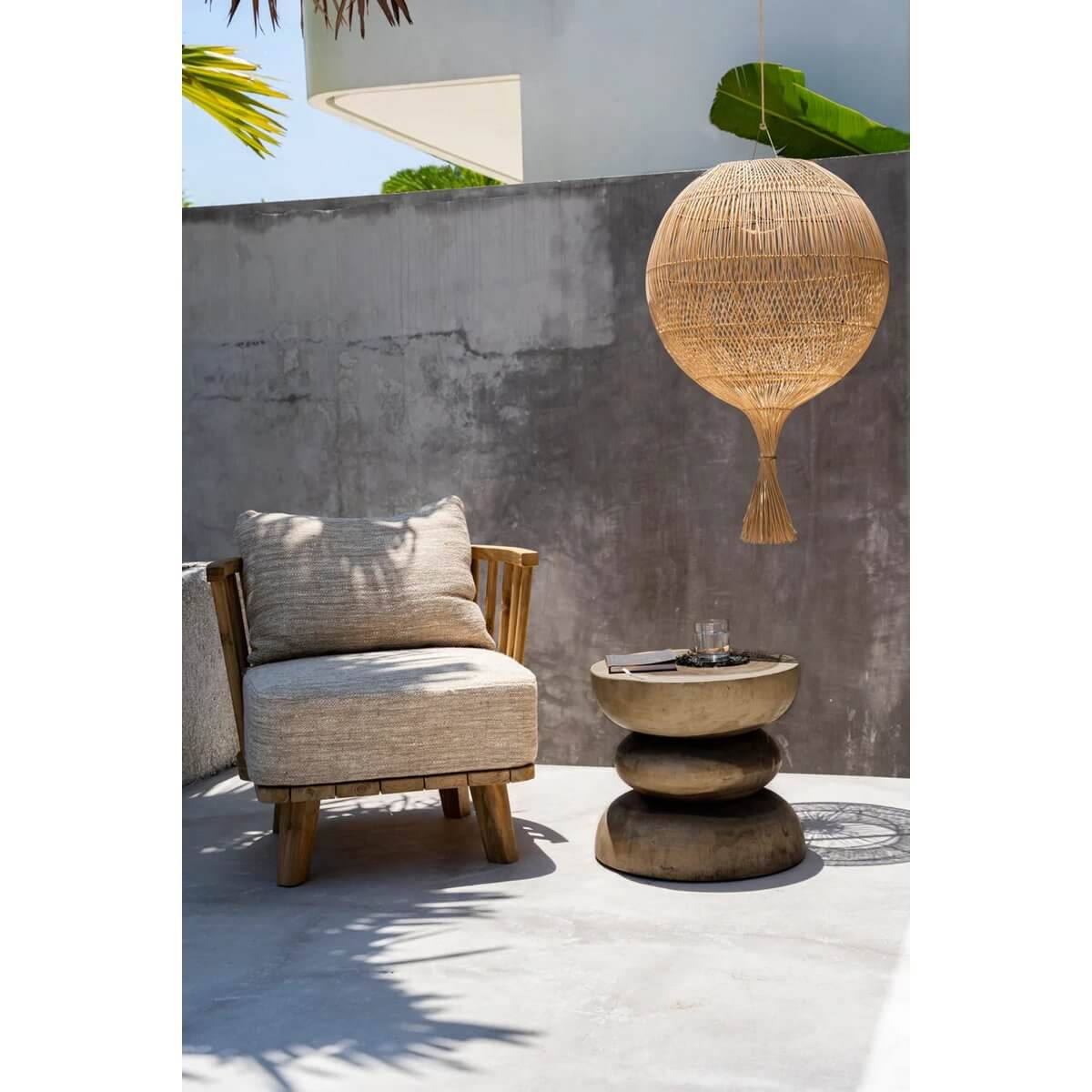 Bohemian outdoor space with De Corfu-kruk as a stylish Mungurr-wood side table next to a cozy chair and wicker lamp shade. Perfect for patios.
