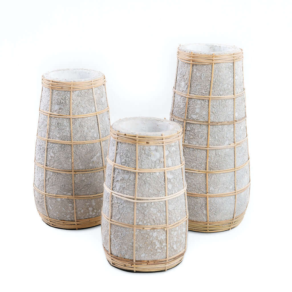 Drie terracotta vazen met rotan details in betongrijs naturel, perfect voor droogbloemen - sfeer van een kusthuis.