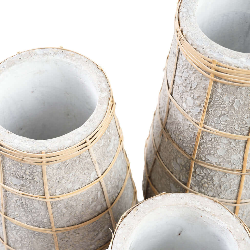 Stijlvolle betongrijze terracotta vazen met rotan detail voor droogbloemen, ideaal voor interieurdecoratie in kuststijl.