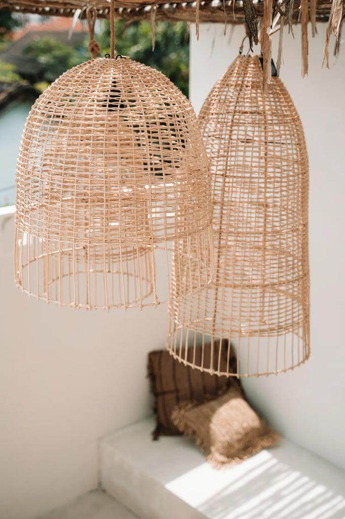 De Elba kooivormige rotan hanglampen in natuurlijke stijl, geïnspireerd door de Italiaanse kust, hangend buiten voor een zomerse sfeer.