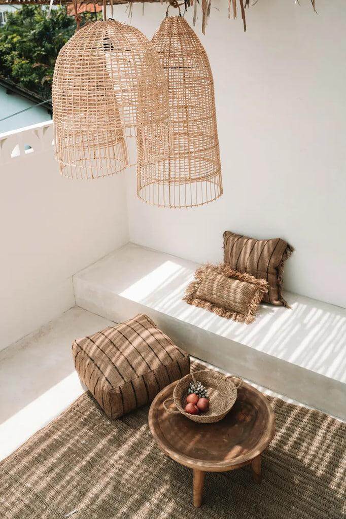 Alt Tag: Kooivormige rotan hanglampen boven strandachtig zithoekje, perfect voor een Italiaanse eilandsfeer. Twee maten beschikbaar, ideaal voor elke ruimte.