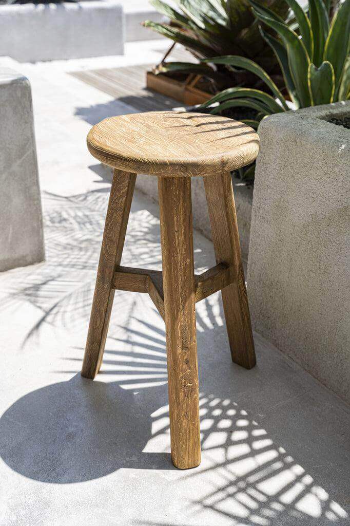 Rustieke teakhouten Fusuma Barkruk buiten op terras tussen groen, benadrukt natuurlijke elegantie en duurzame productie.