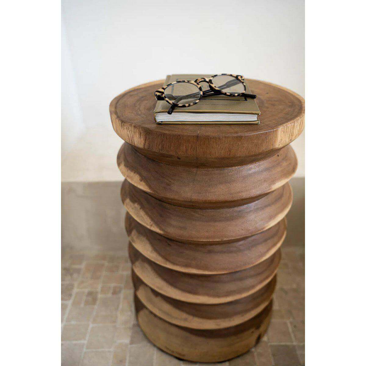 Stijlvolle Galapagos kruk van hoogwaardig hout, met boeken en bril bovenop, in natuurlijke uitvoering voor elk interieur.