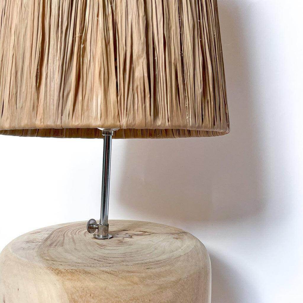 De Grass Teak houten tafellamp met natuurlijke houten basis en rieten kap, creëert een Griekse resort sfeer in elke kamer.