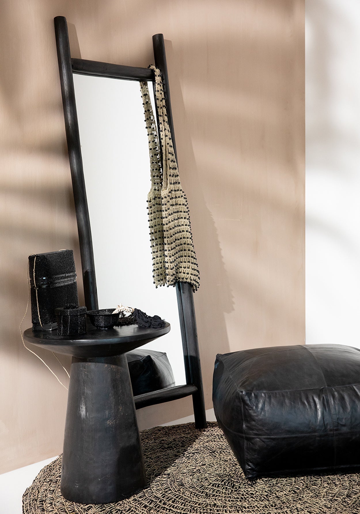 De Island Dressing Spiegel Zwart in een elegante kleedkamer met een poef en bijzettafel, een stijlvol handgemaakt interieurstuk.