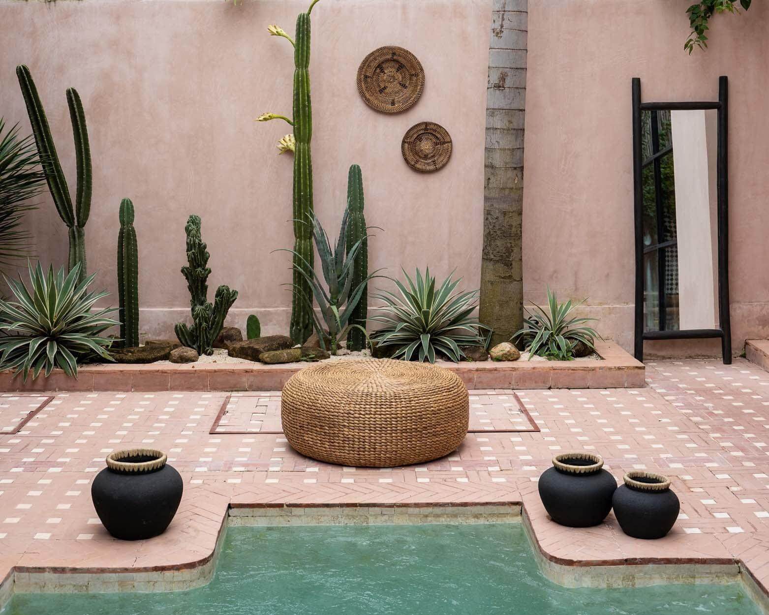 Stijlvolle Island Dressing Spiegel Zwart tegen een muur in een moderne tuin met groen, ideaal voor ruimtelijke interieurdecoratie.