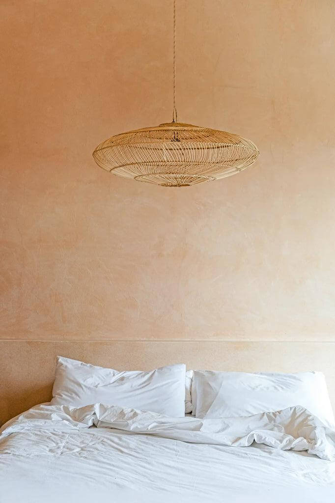 De Macaron Hanglamp - Naturel - Rotan lamp boven een bed, handgemaakt voor een speelse elegante sfeer in elke kamer.