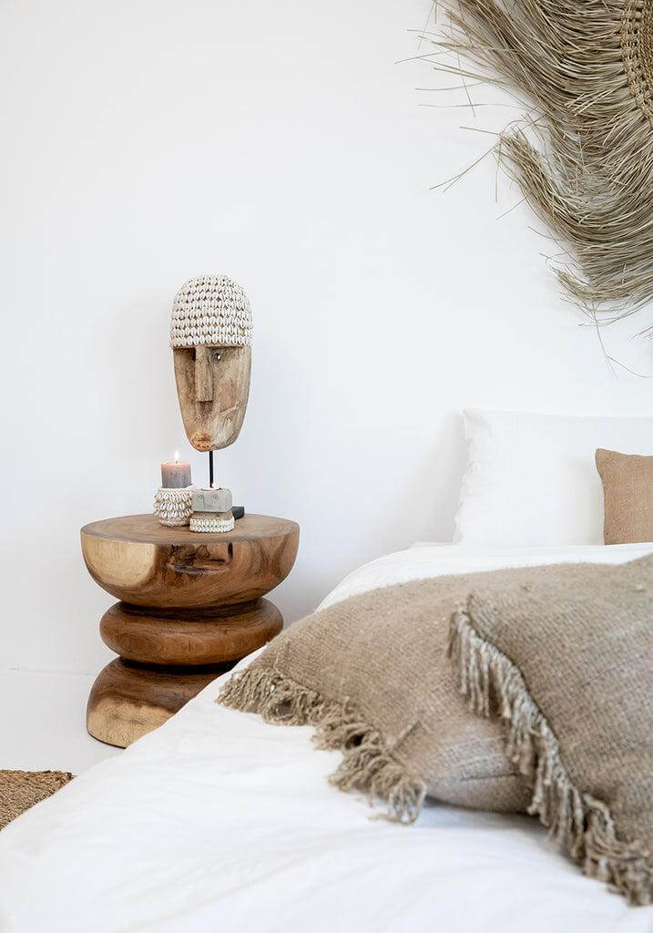 Alt Tag: Kussenhoes beige op bed met houten decoratie, boho-sfeer in slaapkamer, zonder binnenkussen, stijlvolle inrichting.