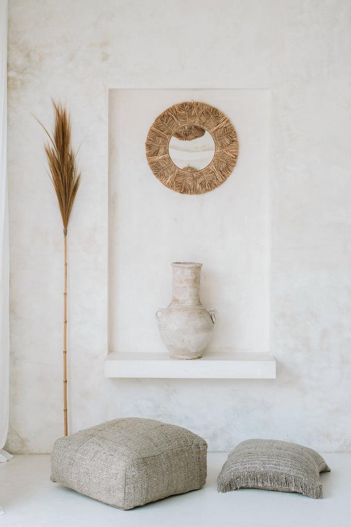 Boho-chique interieur met beige kussenhoes in zacht katoen, omringd door decoratieve elementen. Perfect voor een stijlvolle inrichting.