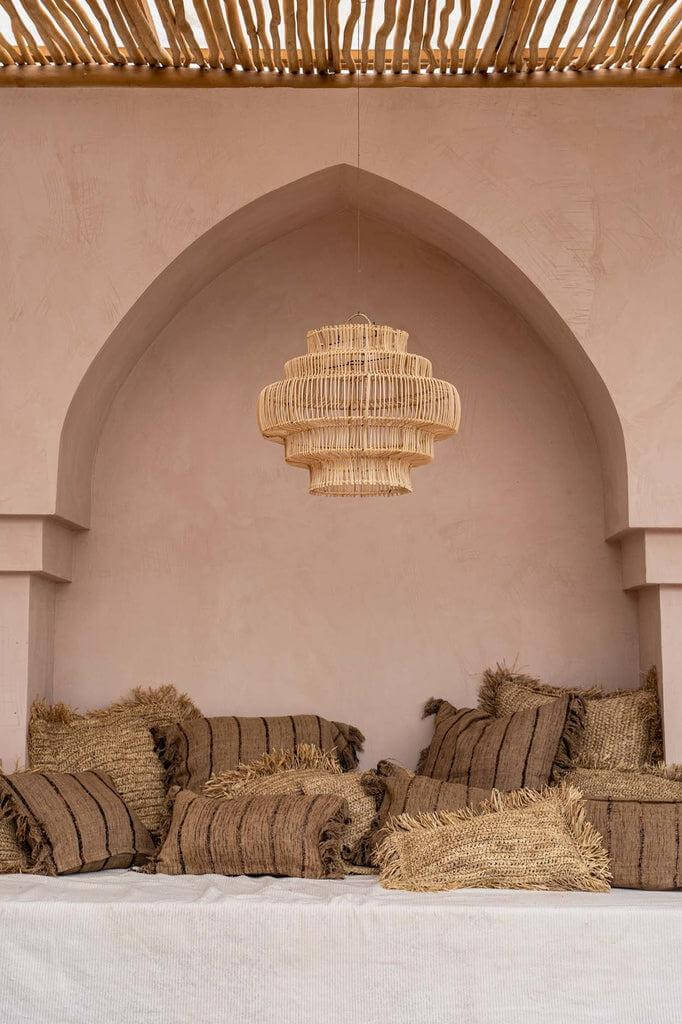 Boho zithoek met beige en zwarte kussenhoezen, zachte katoenen texturen, perfect voor een chique patio of interieur.