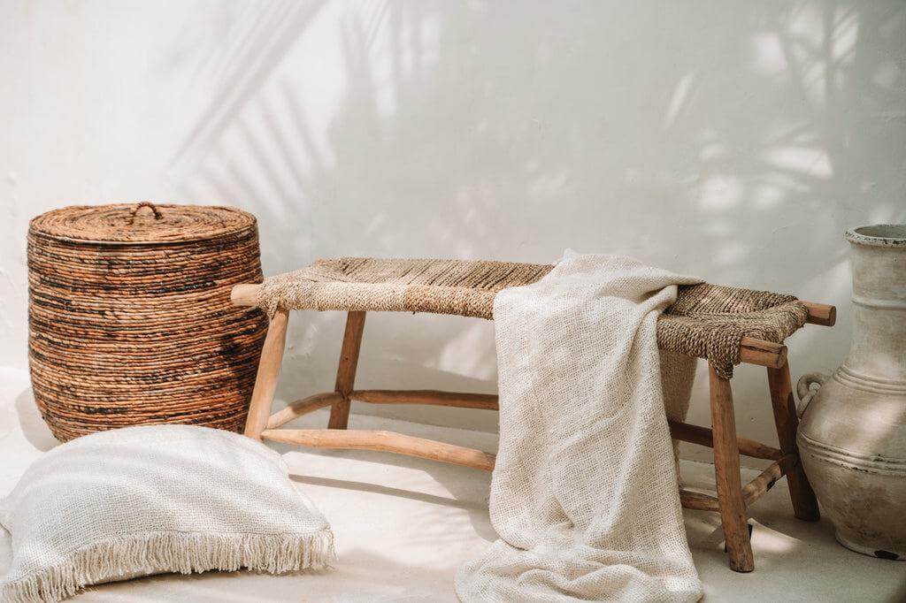 Gezellige boho-stijl interieur met crème kussenhoes en natuurlijke elementen voor een chique uitstraling.