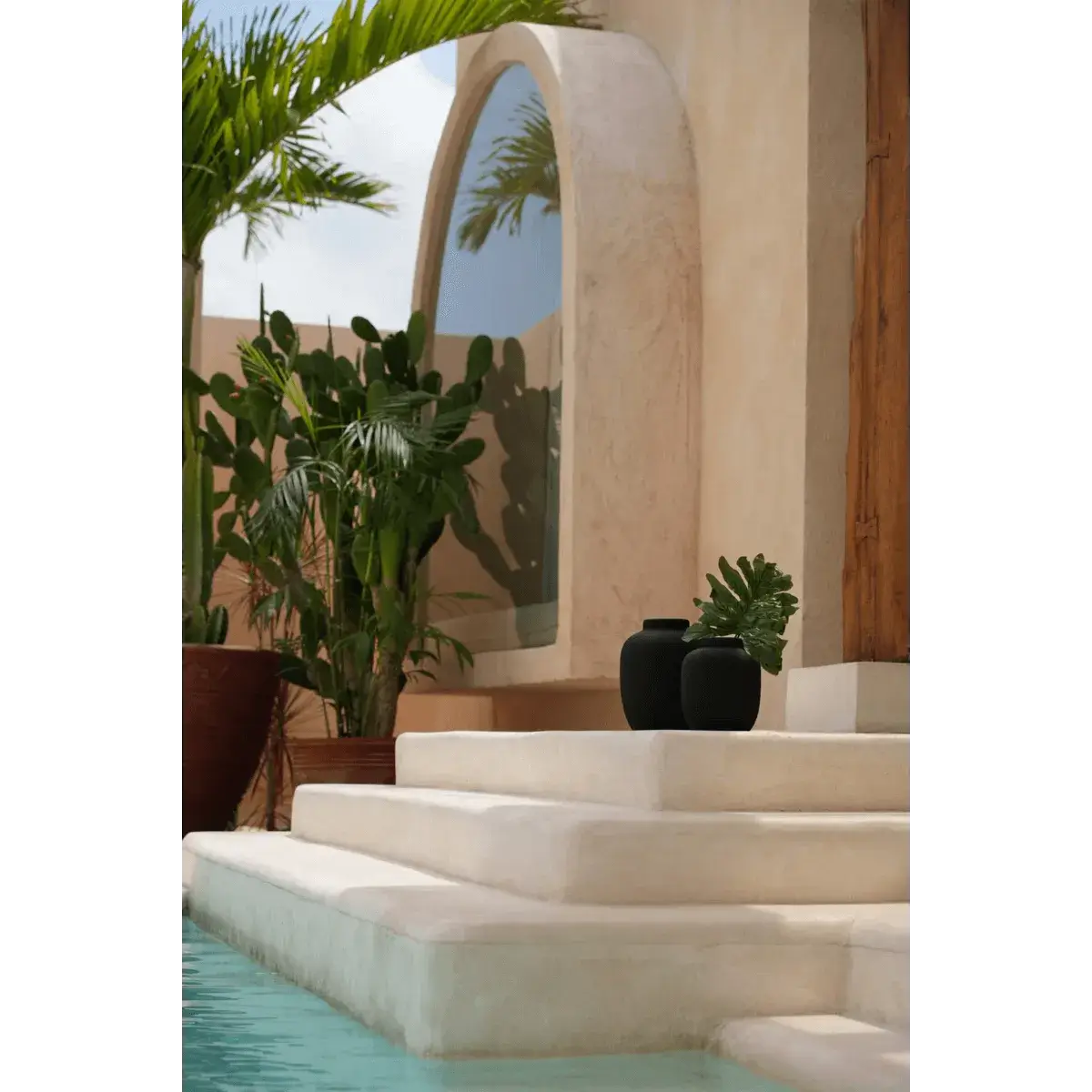 Elegant bohemian decor with De Peaky Vaas in black on a sunlit terrace next to tropical plants.