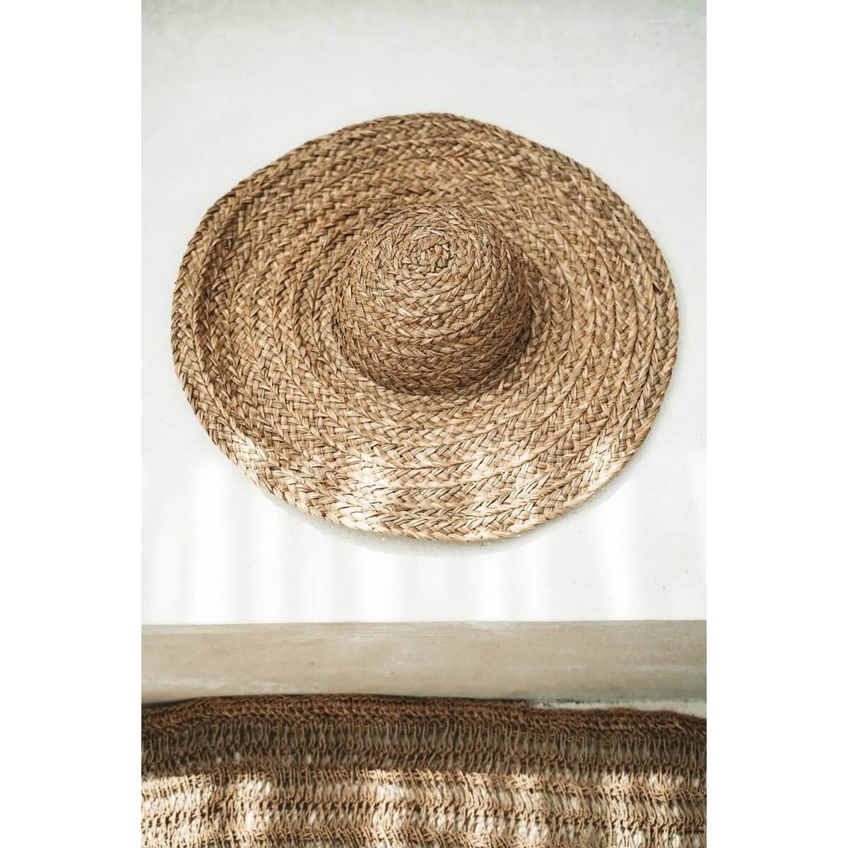 Bohemian straw hat made from water hyacinth, perfect for sunny days, with a natural beige color, enhancing any outdoorsy outfit.