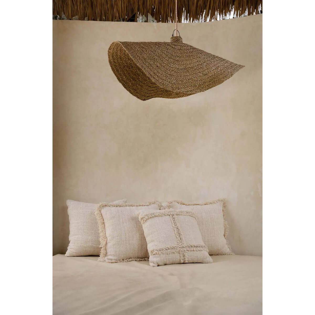 Bohemian De Qubba Hanger in naturel XL woven water hyacinth lampshade creating cozy light patterns over a serene coastal-inspired setting.