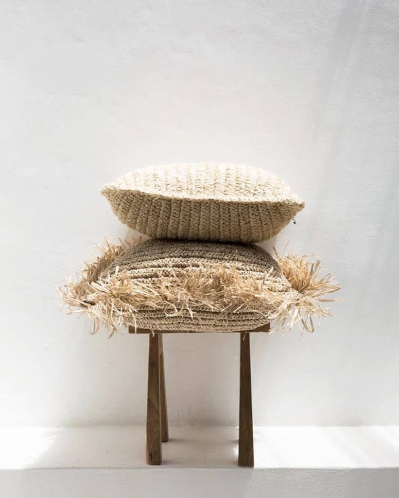 Handgemaakte natuurlijke raffia kussenhoes uit Indonesië, boho-stijl, op houten stoel, perfecte textuur voor interieurdecoratie.