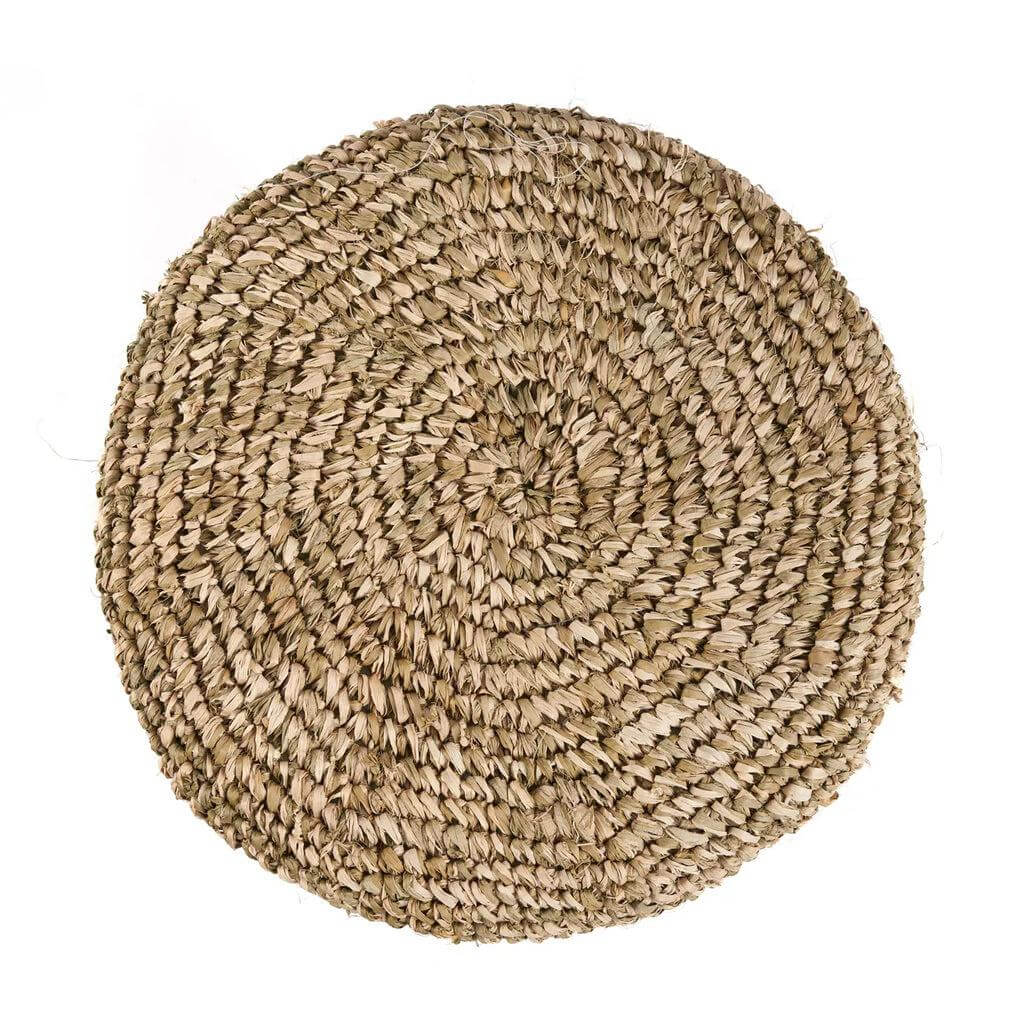 Raffia gevlochten ronde mat met natuurlijke textuur, perfect voor decoratie en functionaliteit in huis.