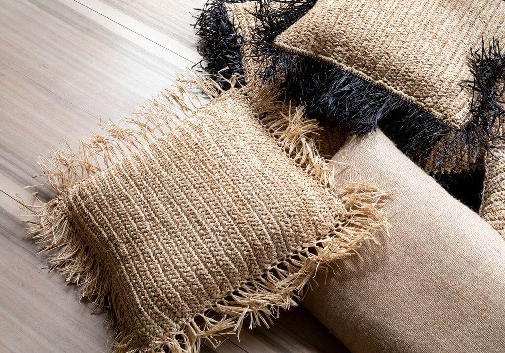 Alt Tag: Handgeweven raffia kussenhoes in naturel en zwart op houten vloer, boho sfeer, 40x40 cm, zonder binnenkussen.
