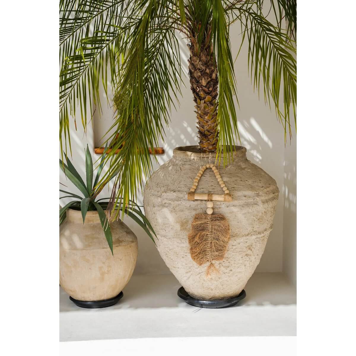 Large clay pots with decorative raffia and bohemian elements, perfect for adding a natural touch to indoor spaces.