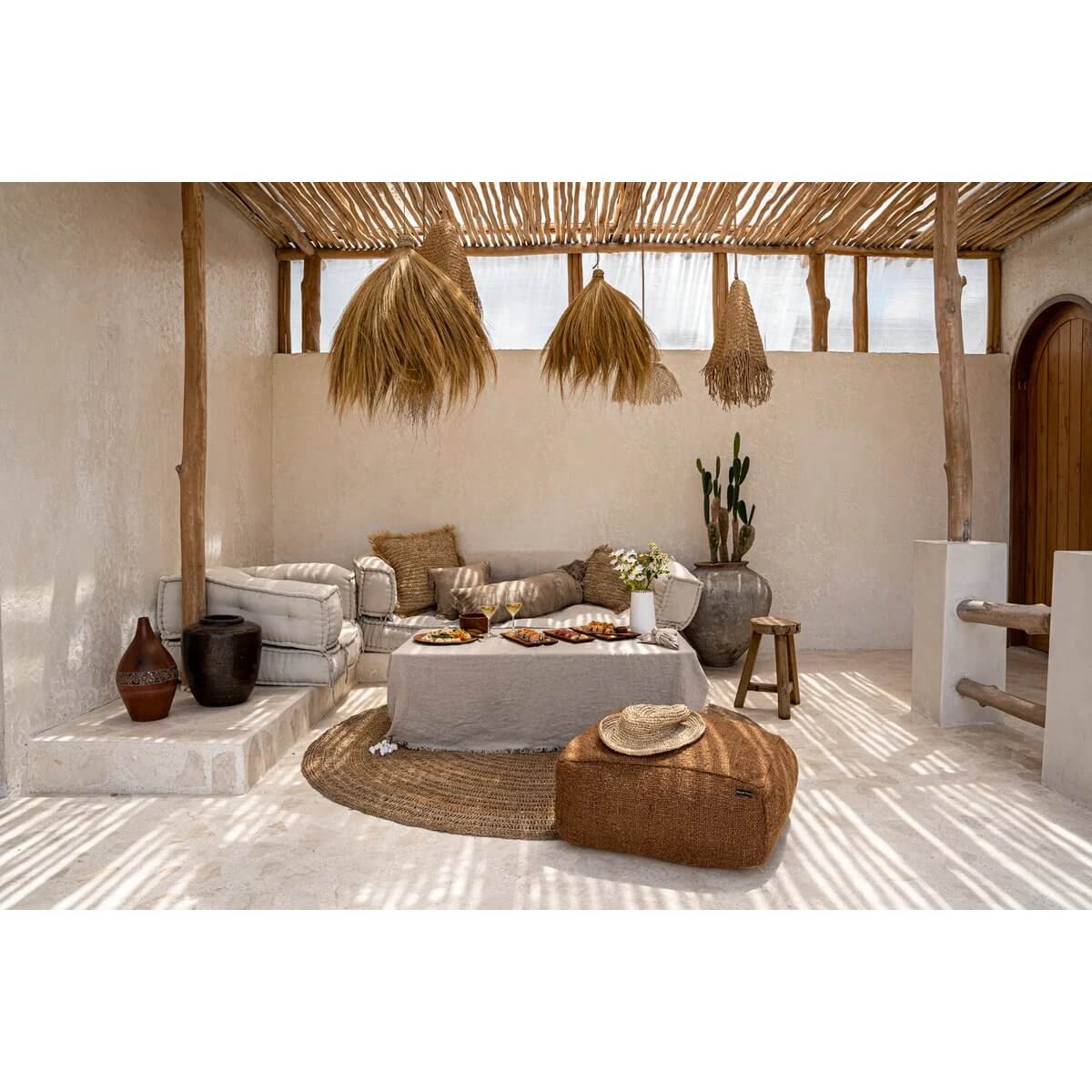 Gezellige zithoek met De Rayung Hut-hanger hanglampen, natuurlijke grastinten en boho-stijl inrichting, perfect voor relaxte sfeer.