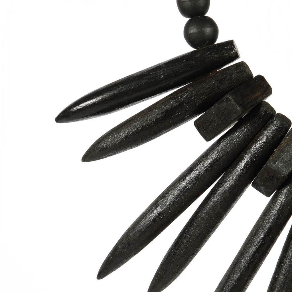 Close-up van houten ornamenten op de rayongrasscherm in zwart, met een boho touch voor interieur- en tuinversiering.