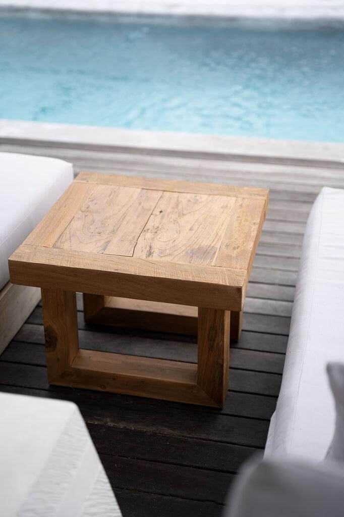 Bijzettafel van gerecycled teakhout bij een zwembad, duurzaam en stijlvol design voor buitenruimtes.
