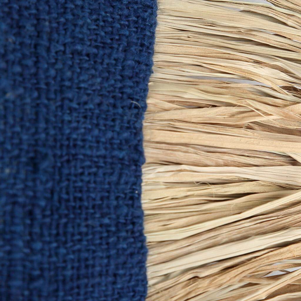 Close-up van De Saint Tropez kussenhoes in blauw en naturel katoen met raffia franjes, 30x50 cm. Boho tint voor huis of tuin.