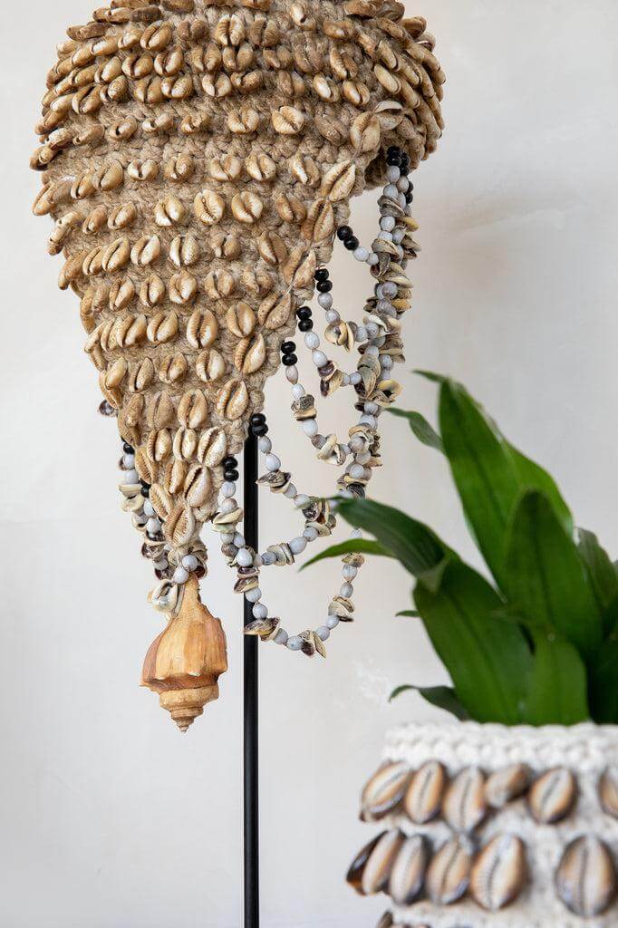 Alt Tag: Handgemaakt kunstwerk "De Schelpen Hoed" met schelpen en veren uit Bali, perfecte decoratie op standaard voor huisinterieur.